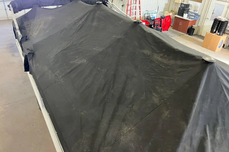 Slide: The Image of 2019 SunChaser Geneva Fish 20 Cnf boat covered with a black tarp in a garage. - 46