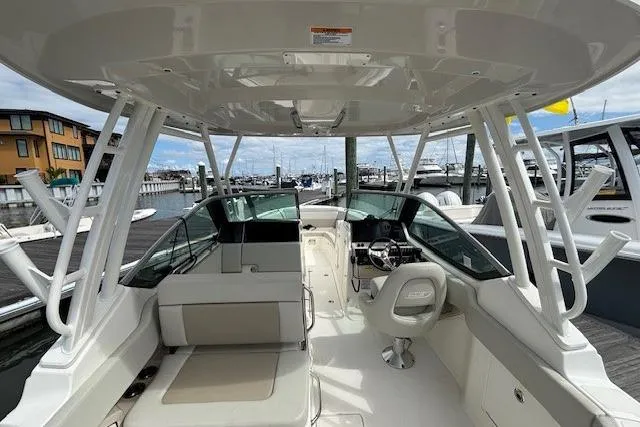 Slide: The Image of 2022 Boston Whaler 240 Vantage boat interior at marina, showcasing seating and helm. - 16