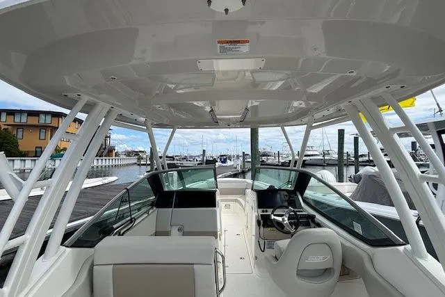 Slide: The Image of 2022 Boston Whaler 240 Vantage boat interior at marina, showcasing helm and seating area. - 18