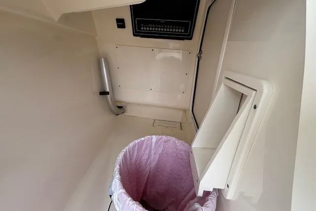 Slide: The Image of 2022 Boston Whaler 240 Vantage interior storage compartment with trash bin. - 21