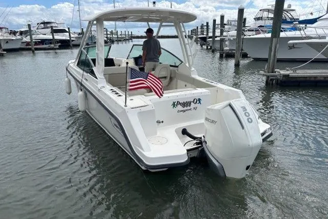 Slide: The Image of 2022 Boston Whaler 240 Vantage boat docked, featuring a Mercury engine and American flag. - 3