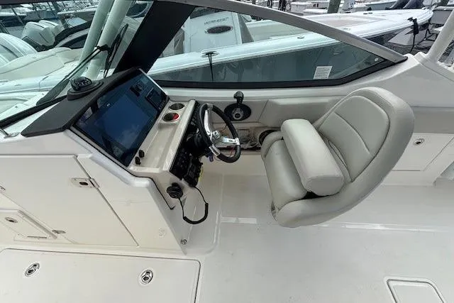 Slide: The Image of 2022 Boston Whaler 240 Vantage boat cockpit with steering wheel and comfortable seating. - 9