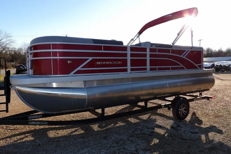 Slide: The Image of 2026 Bennington 21 S L-Bench pontoon boat with red exterior on a trailer. - 2