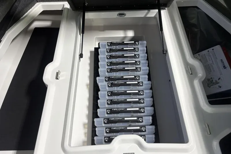 Slide: The Image of Open storage compartment in 2026 Skeeter ZXE20 boat, holding organized tackle boxes. - 10