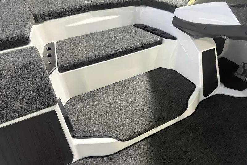 Slide: The Image of 2026 Skeeter ZXE20 boat interior with gray carpeted steps and seating area. - 9