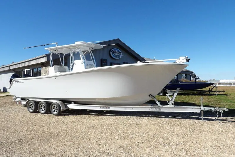 The Image of 2023 Front Runner 33 Center Console boat on a trailer, parked outdoors. - 0