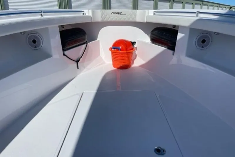 Slide: The Image of 2023 Front Runner 33 Center Console boat interior with orange bucket and storage compartments. - 11