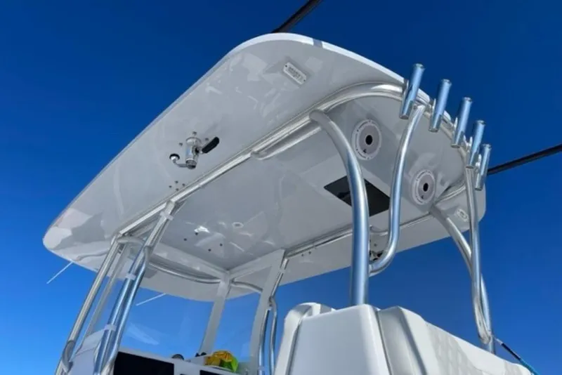 Slide: The Image of 2023 Front Runner 33 Center Console boat with sleek T-top and rod holders against blue sky. - 12