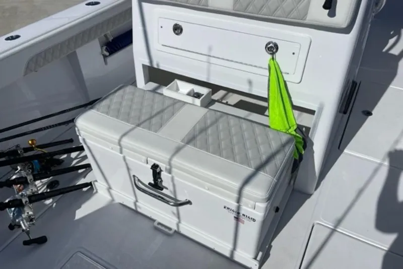 Slide: The Image of 2023 Front Runner 33 Center Console boat interior with fishing rods and storage compartment. - 18