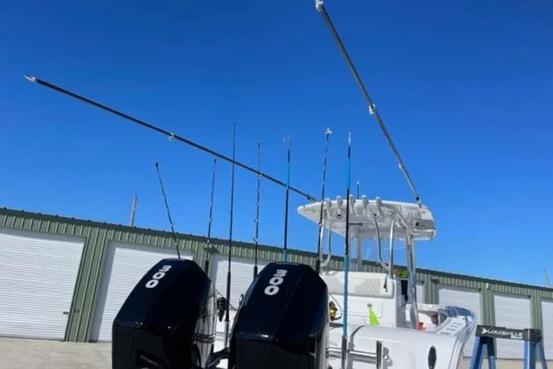 Slide: The Image of 2023 Front Runner 33 Center Console boat with dual engines and fishing rods, under clear blue sky. - 8