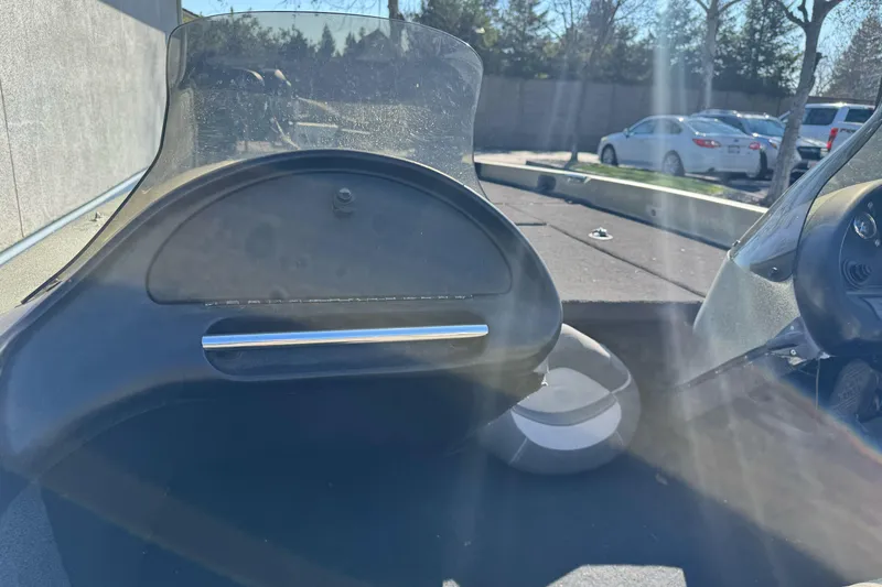 Slide: The Image of 1997 Ranger 488VS boat dashboard with windshield, parked outdoors in sunlight. - 14