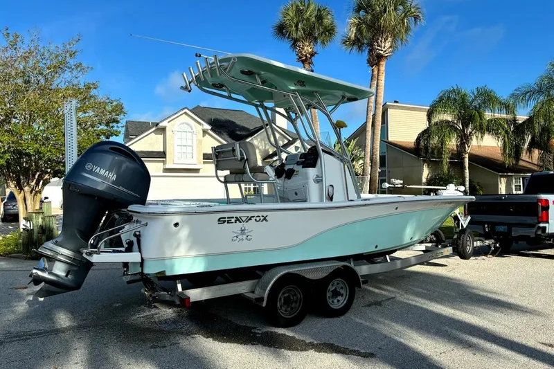 Slide: The Image of 2016 Sea Fox 220 Viper boat on trailer, parked near palm trees and houses. - 4