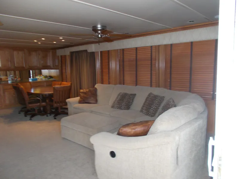 Slide: The Image of Interior of 2005 Sumerset Lake Bumz houseboat with beige sofa and dining area. - 10