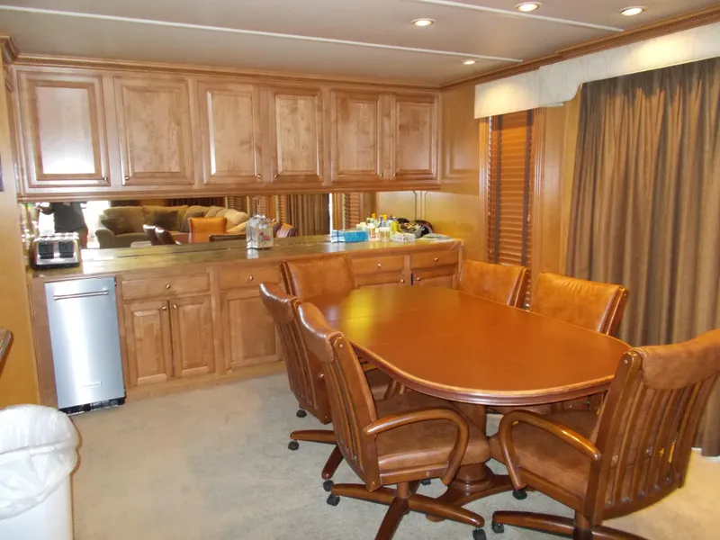 Slide: The Image of 2005 Sumerset Lake Bumz houseboat dining area with wooden table and chairs. - 13