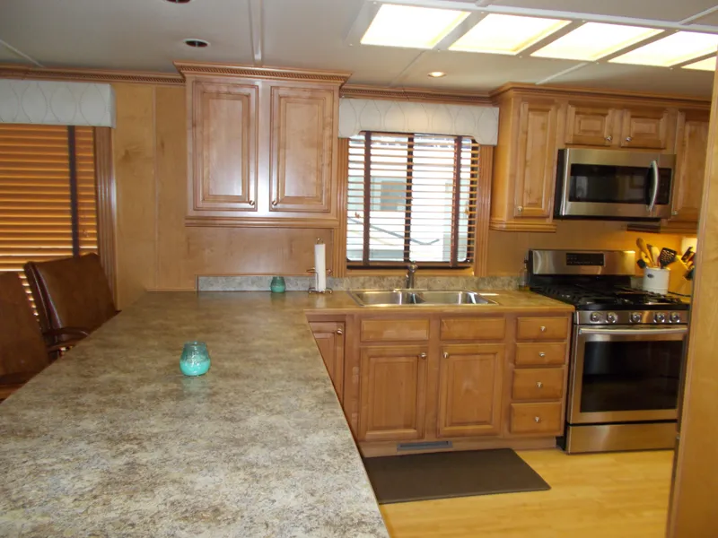 Slide: The Image of Modern kitchen in a 2005 Sumerset Lake Bumz houseboat with wooden cabinets and stainless steel appliances. - 14
