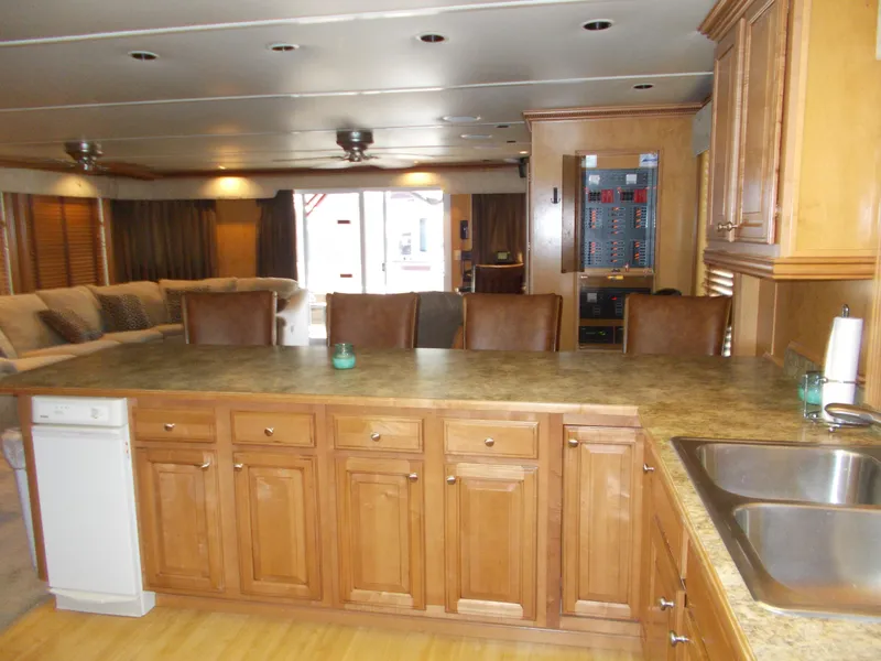 Slide: The Image of 2005 Sumerset Lake Bumz houseboat kitchen with wooden cabinets and spacious living area. - 15