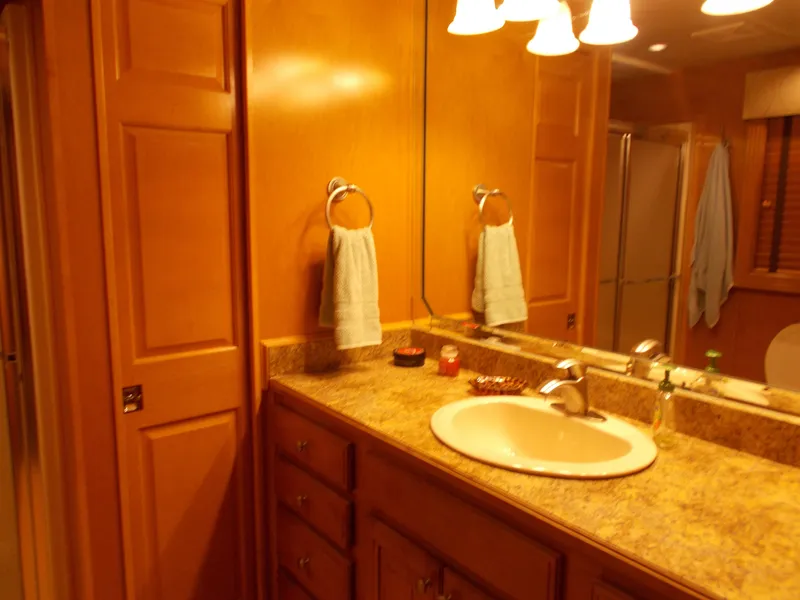 Slide: The Image of 2005 Sumerset Lake Bumz houseboat bathroom with wooden cabinets and a granite countertop. - 31
