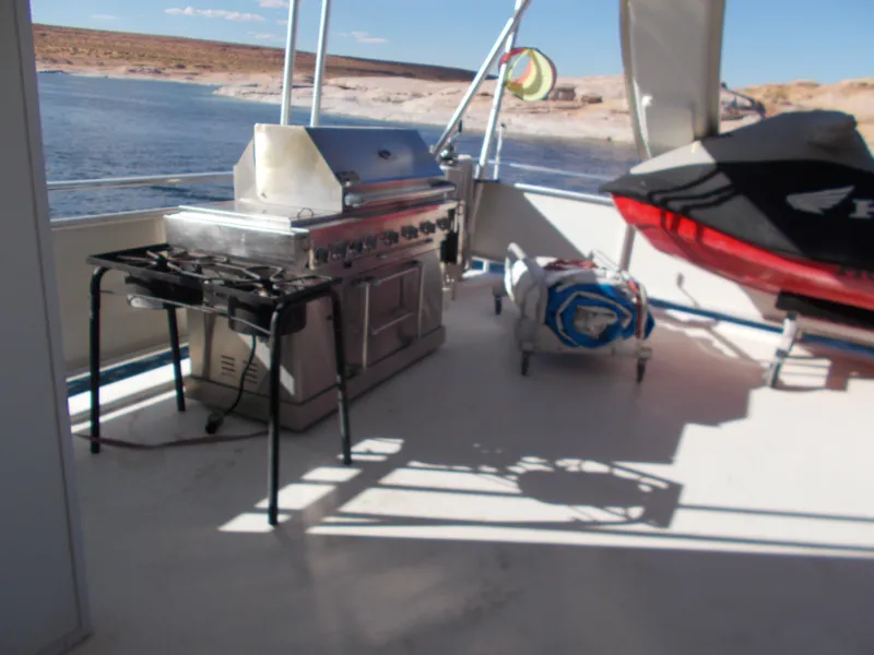 Slide: The Image of Outdoor deck of 2005 Sumerset Lake Bumz houseboat with grill and watercraft. - 37