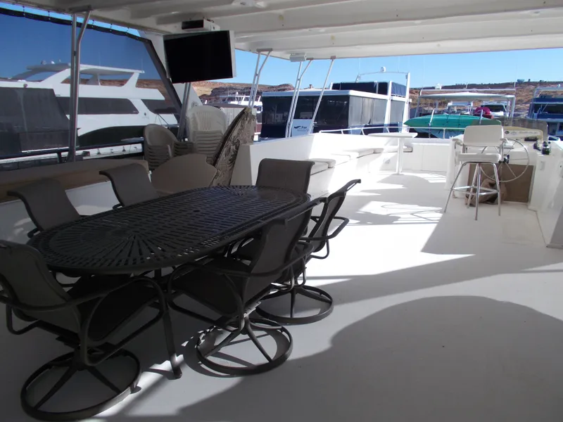 Slide: The Image of 2005 Sumerset Lake Bumz houseboat with spacious outdoor seating area and marina view. - 40