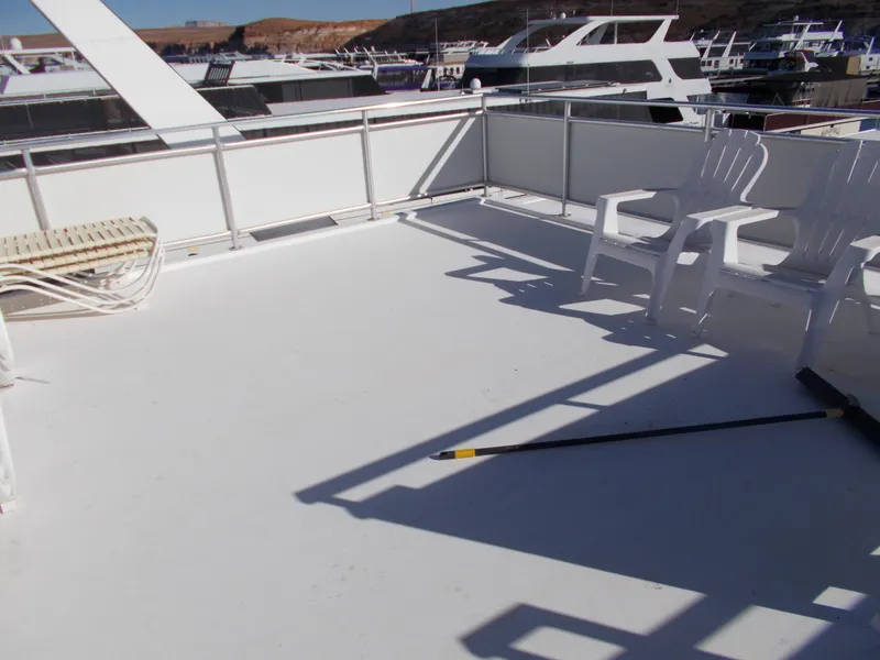 Slide: The Image of Upper deck of 2005 Sumerset Lake Bumz houseboat with white chairs and railing. - 44