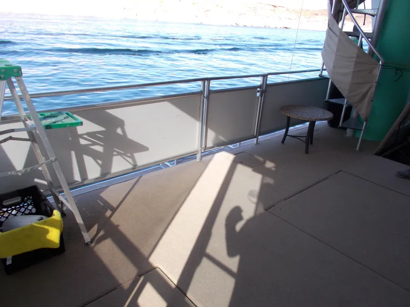 Slide: The Image of Sumerset Lake Bumz 2005 houseboat deck with lake view, ladder, and table. - 47