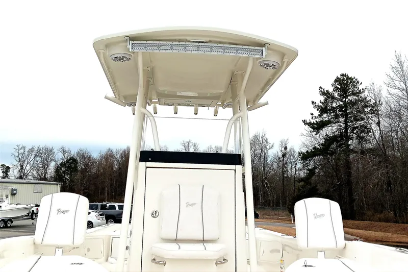 Slide: The Image of 2022 Ranger 2510 Bay boat with T-top and seating, surrounded by trees. - 12