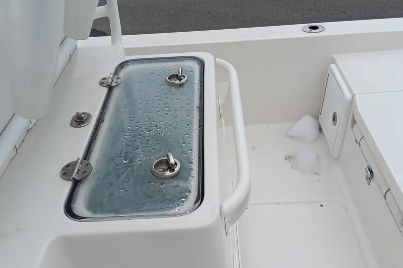 Slide: The Image of 2022 Ranger 2510 Bay boat deck with wet storage compartment and ice remnants. - 18