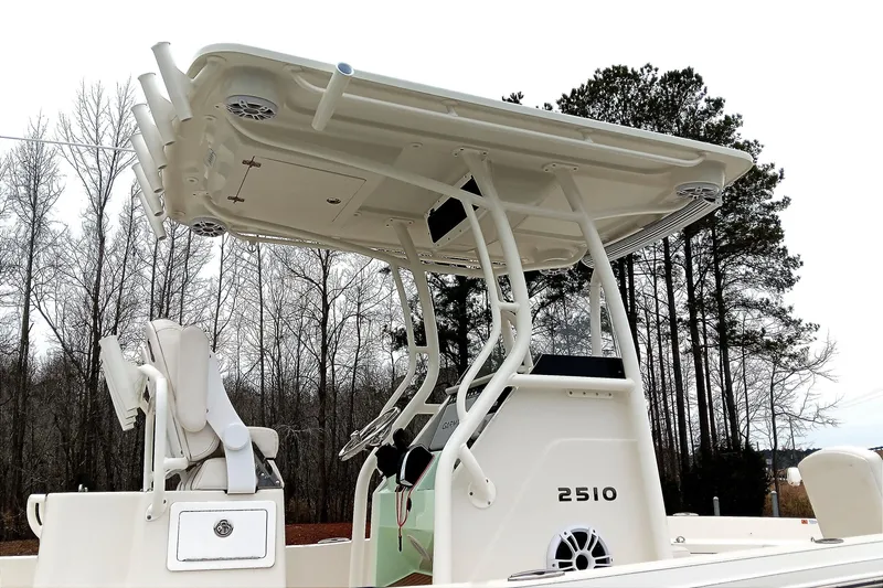 Slide: The Image of 2022 Ranger 2510 Bay boat with T-top and seating, surrounded by trees. - 21