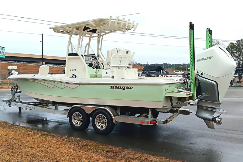 Slide: The Image of 2022 Ranger 2510 Bay boat on trailer with Mercury engine, parked outdoors. - 4