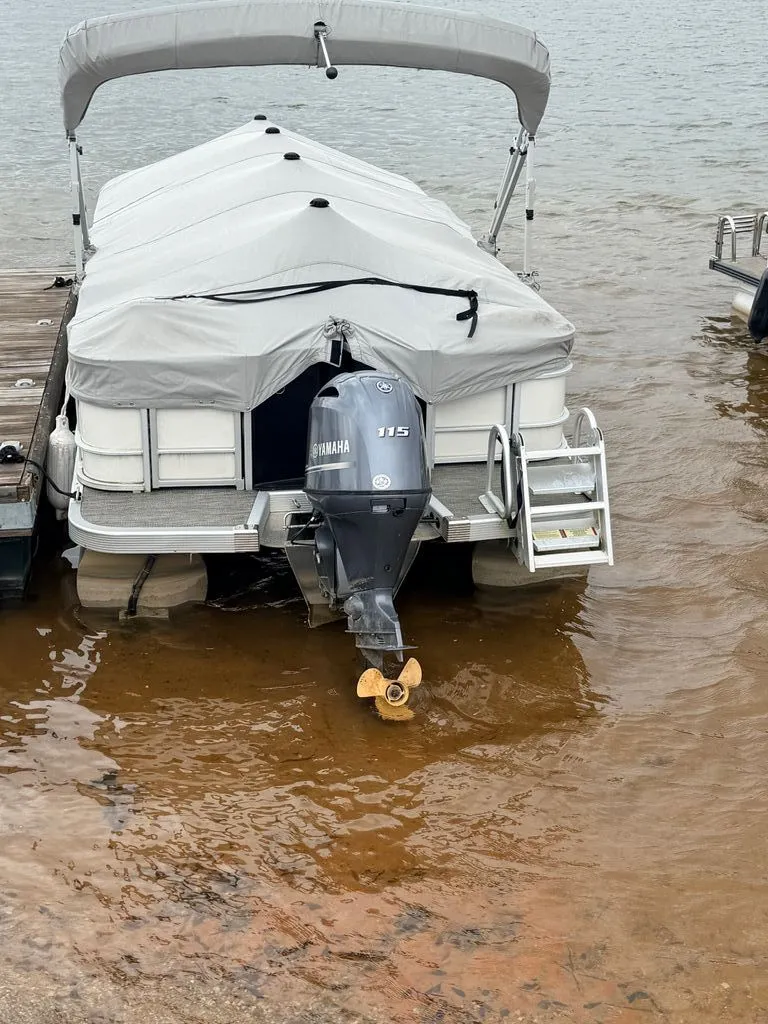 Slide: The Image of 2023 Bennington SX 22 pontoon boat docked with cover. - 2