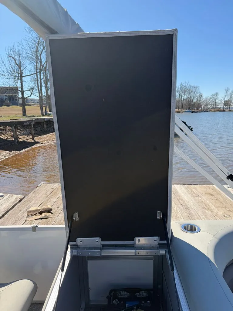 Slide: The Image of Bennington SX 22 boat with open storage compartment by the lake, 2023 model. - 21