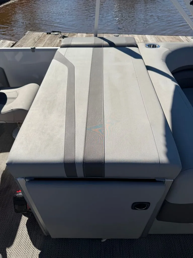 Slide: The Image of Bennington SX 22 2023 boat, gray upholstery, docked by water. - 22