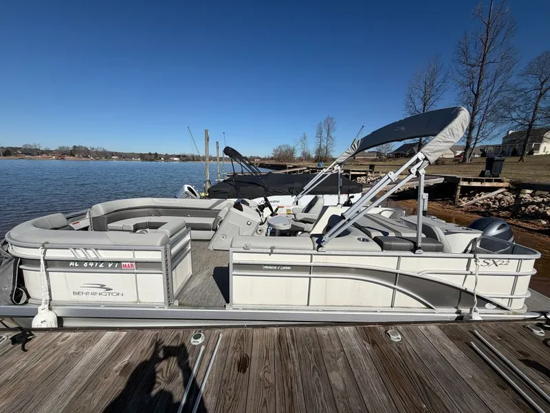 Slide: The Image of 2023 Bennington SX 22 pontoon boat at lakeside dock. - 30