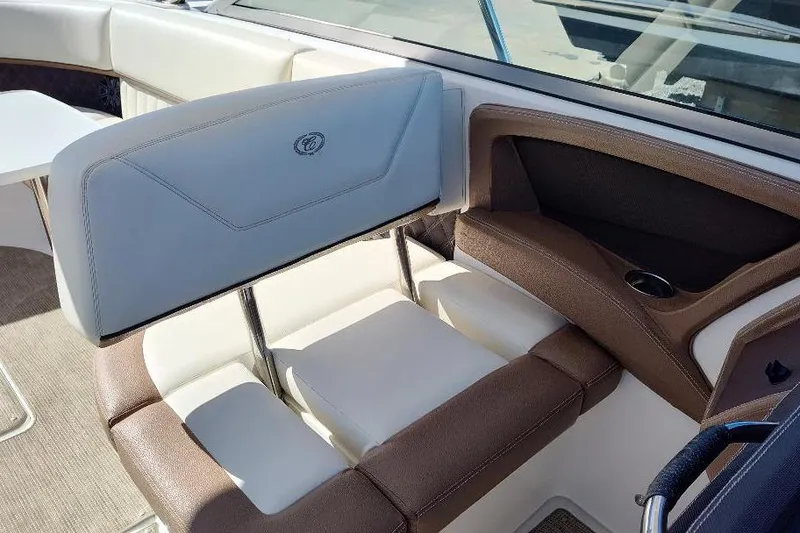 Slide: The Image of 2016 Cobalt 302 boat interior with brown and white seating, cup holder, and table. - 17