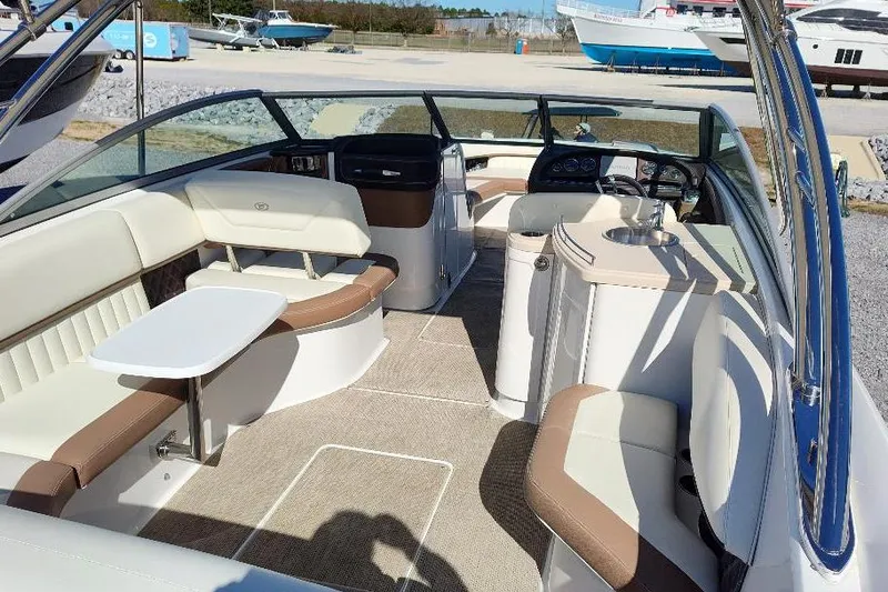 Slide: The Image of 2016 Cobalt 302 boat interior with seating and helm, docked outdoors. - 18