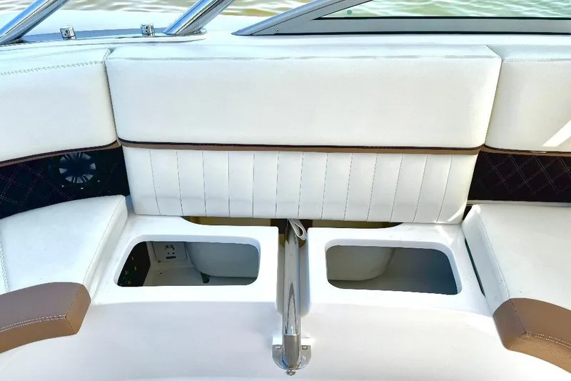 Slide: The Image of 2016 Cobalt 302 boat interior with white seating and storage compartments. - 20