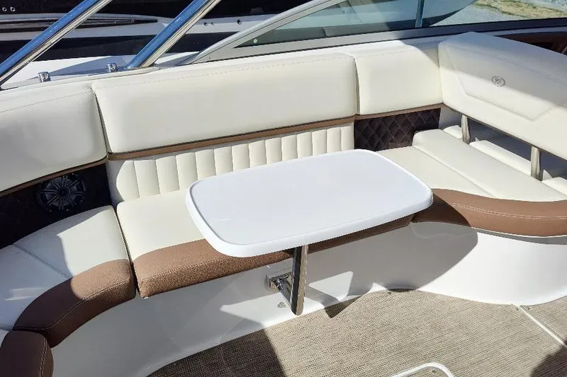 Slide: The Image of Luxurious seating area on a 2016 Cobalt 302 boat with a small table. - 25