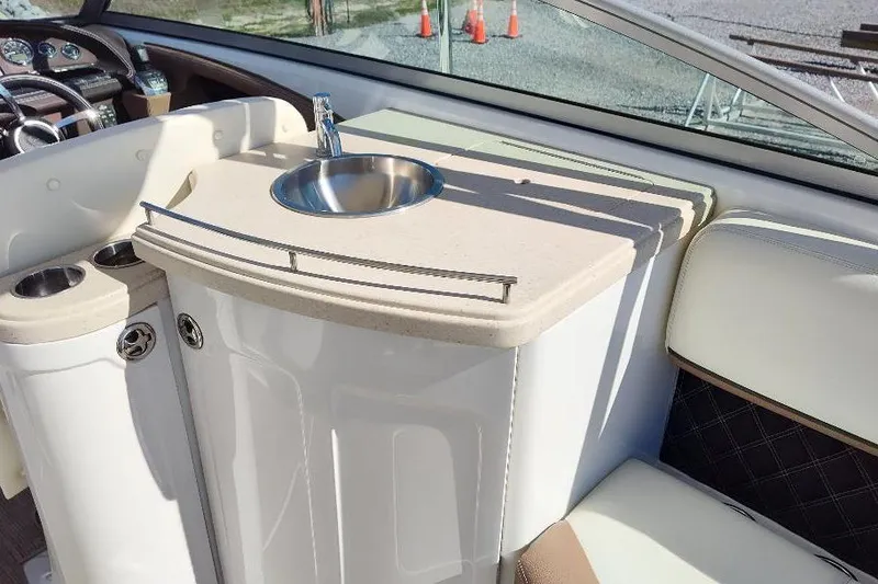 Slide: The Image of Interior of 2016 Cobalt 302 boat featuring a compact sink and seating area. - 26