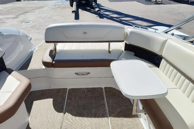 Slide: The Image of 2016 Cobalt 302 boat interior with white and brown seating, small table. - 28