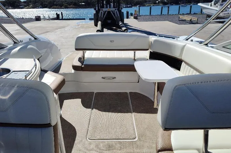 Slide: The Image of 2016 Cobalt 302 boat interior with seating and table, docked by the water. - 29