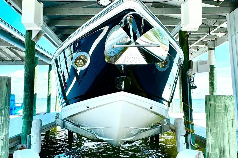 Slide: The Image of 2016 Cobalt 302 boat docked in a marina, viewed from the front. - 3