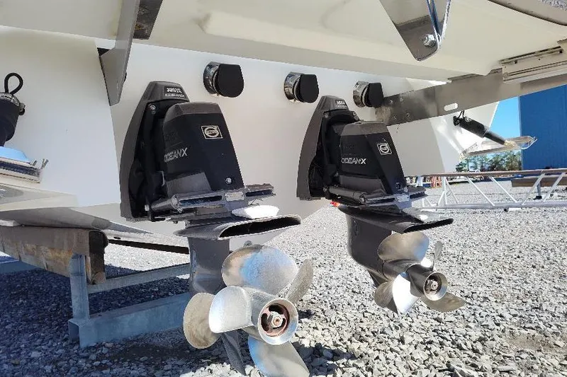 Slide: The Image of 2016 Cobalt 302 boat with dual OceanX outdrives and propellers on gravel surface. - 9