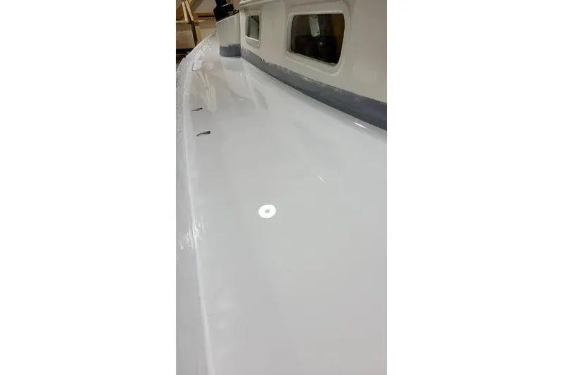 Slide: The Image of 1977 Fuji 45 MK II Ketch deck, showcasing sleek white surface and windows. - 36