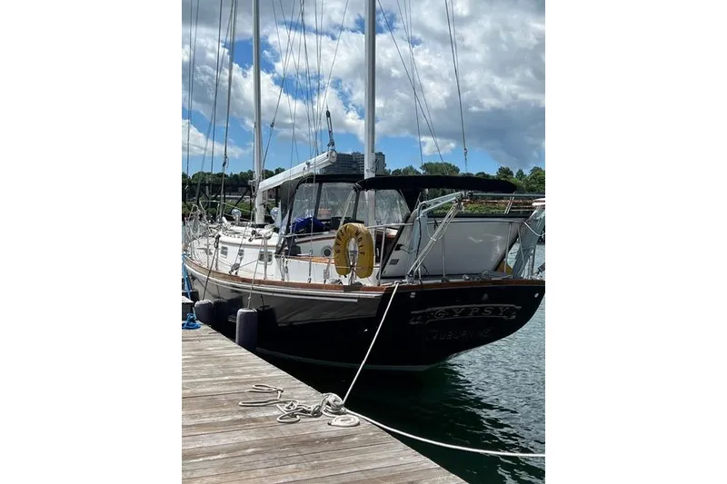 Slide: The Image of 1977 Fuji 45 MK II Ketch sailboat docked under a partly cloudy sky. - 56