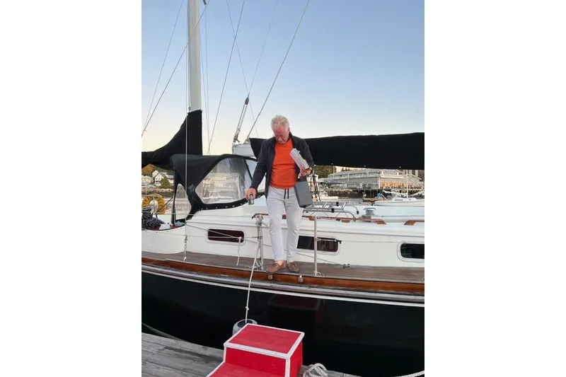 Slide: The Image of Man on 1977 Fuji 45 MK II Ketch sailboat at dock, holding papers. - 60
