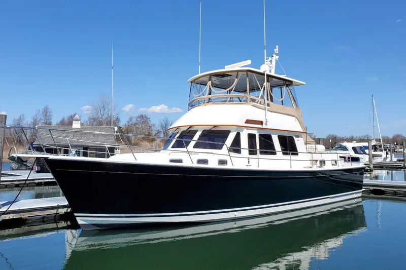 The Image of 2002 Sabreline 47 yacht docked in a marina under clear blue skies. - 0