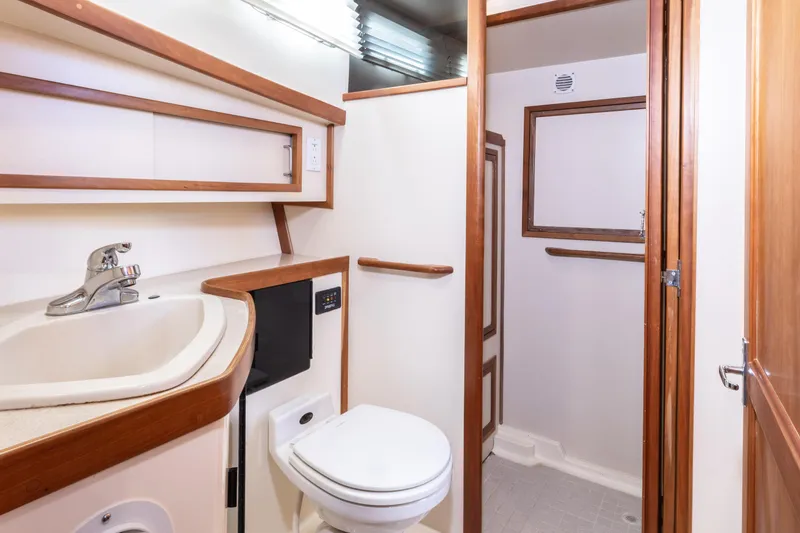 Slide: The Image of 2002 Sabreline 47 yacht bathroom with sink, toilet, and shower area. - 13