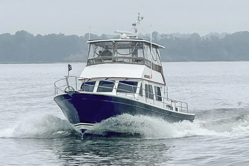 Slide: The Image of 2002 Sabreline 47 yacht cruising on a misty lake. - 20