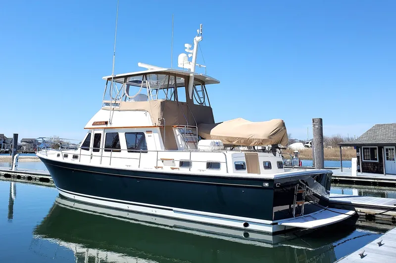 Slide: The Image of 2002 Sabreline 47 yacht docked in a marina under clear blue skies. - 21