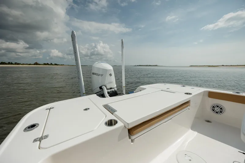 Slide: The Image of 2025 Caymas 26 HB boat on calm water, showcasing spacious deck and Mercury engine. - 10